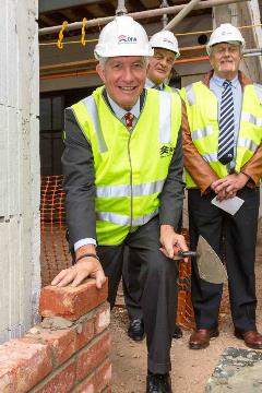 Photo of DHA Chairman, Hon Sandy Macdonald, laying the first bricks at the Prince's Terrace Adelaide site event