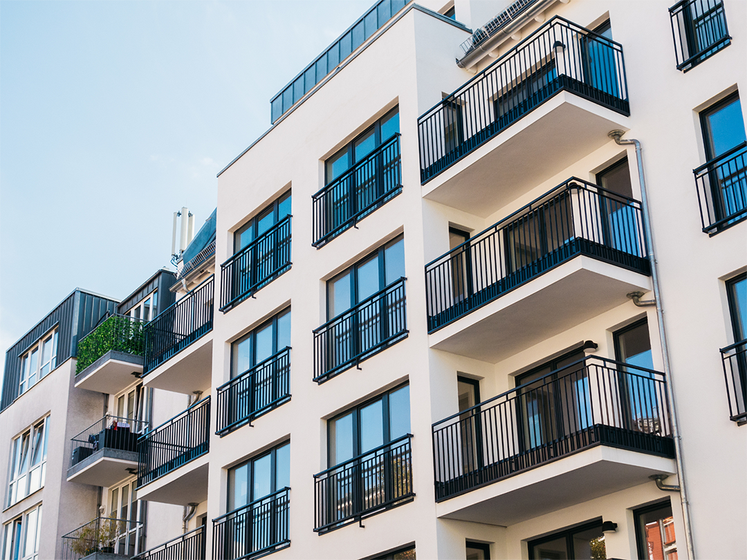 White apartment building against a light blue sky