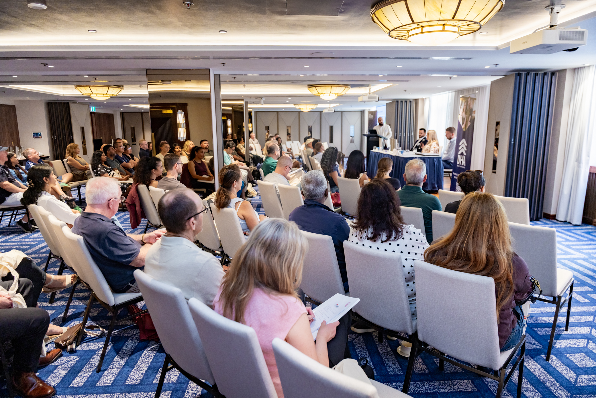 Group of people sitting theatre style with backs to the camera
