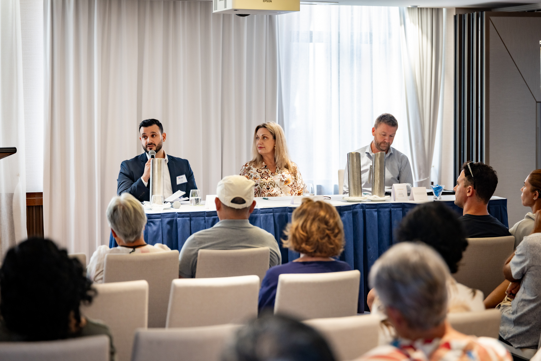 Three people sitting behind a desk