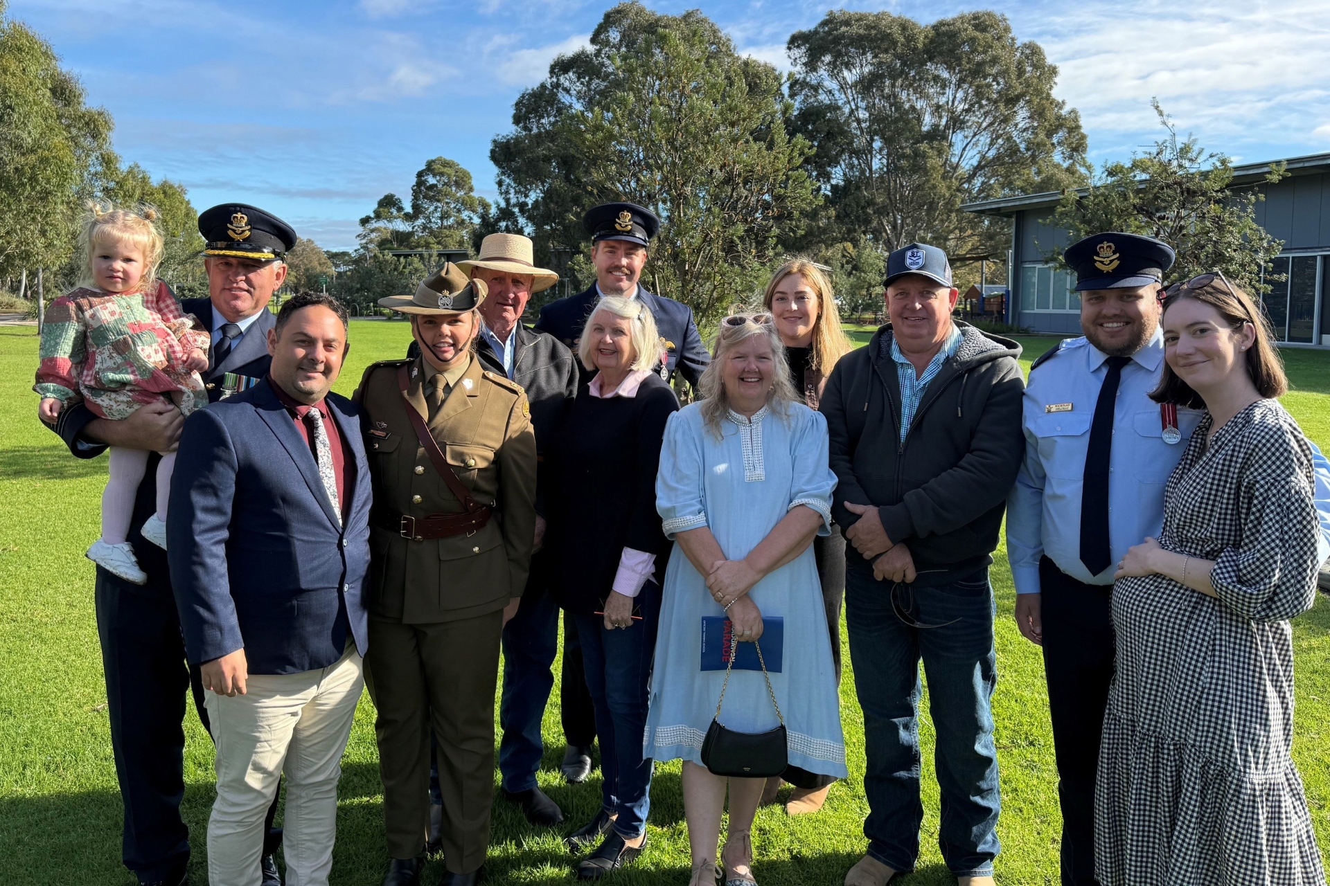Large group of people posing for a family photo with some of the group dressed in Defence uniform 