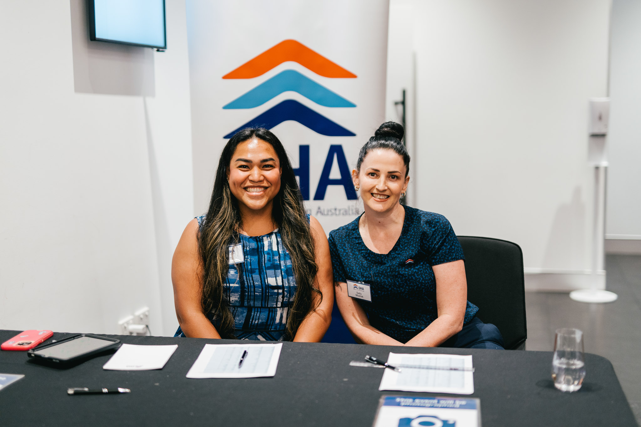Two women sitting at check-in desk